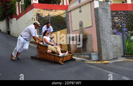 Funchal Madeira Frau und kleines Mädchen mit bergab Korbfahrt. Stockfoto