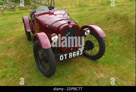 Vintage Dark Red 1928 Austin Seven geparkt auf Gras. Stockfoto