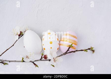 Ostern bunte Eier mit Blüte Frühling Zweig auf texturierten Beton Hintergrund mit einem Kopierraum. Stockfoto