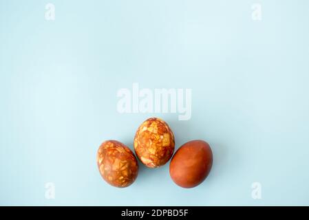 Drei braune Ostereier auf blauem Hintergrund mit einer Kopie Platz Stockfoto