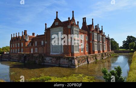 Helmingham Hall mit Graben Brücken und Reflexionen. Stockfoto