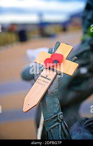 Holzkreuz mit Mohnblume in der Hand der Skulptur Willkommen zu Hause, an der Fleetwood Seafront Stockfoto