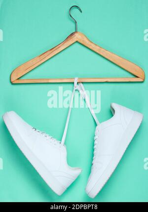 Flache Lay von modernen weißen Sneakers Schuhe mit Hanger auf Pastell Hintergrund. Fotos Von Oben. Youth Lifestyle Konzept Stockfoto