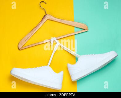 Flache Lay von modernen weißen Sneakers Schuhe mit Hanger auf Pastell Hintergrund. Fotos Von Oben. Youth Lifestyle Konzept Stockfoto
