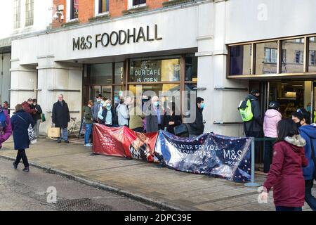 Cambridge, Großbritannien, 19-12-2020. Während der aktuellen Pandemie am letzten Samstag vor Weihnachten warten Menschen vor dem beliebten Lebensmittelgeschäft. Stockfoto