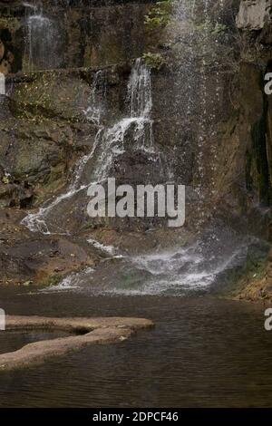 Wasserfall, Wasser fließt den felsigen Felsen hinunter in den See Stockfoto