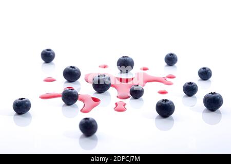 Heidelbeeren mit Safttropfen auf weißem Hintergrund. Stockfoto