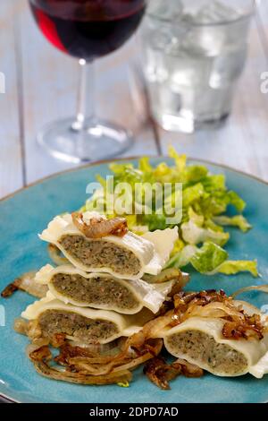 Hälften schwäbische maultaschen Pasta mit Salat Stockfoto