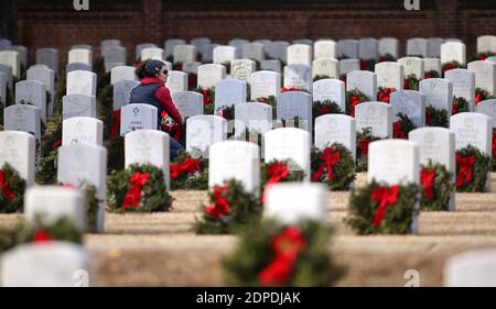 Raleigh, North Carolina, USA. Dezember 2020. ANNA MARIA STIMPSON von Raleigh, NC richtet ein Band auf einem Kranz, als sie sich anderen Freiwilligen hilft, über 5000 Kränze während dieses Jahres Kränze in ganz Amerika auf Raleigh National Cemetery legen. Aufgrund der COVID-19-Einschränkungen war die Kranzniederlegung auf Gruppen von jeweils 50 Personen beschränkt. Der Friedhof, der 1865 gegründet wurde, ist einer von fünf nationalen Friedhöfen, um die Toten der Union zu begraben.Â Er umfasst fast 6,000 Internierungen auf einer Fläche von 7 Hektar. Kränze in ganz Amerika koordiniert wreathÂ--Verlegezeremonien bei mehr als 2,100 lo Stockfoto