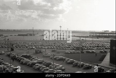 Ende der 1950er Jahre, historische Außenansicht der Start- und Landebahn und geparkte Autos am London Airport, später als London Heathrow Airport umgemahmt. Auf der rechten Seite sind Bauarbeiten an einem neuen Terminal zu sehen. Stockfoto