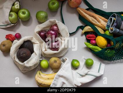 Overhead-Ansicht eines gesunden und nachhaltigen Einkaufs. Einige ökologische, Mesh-Taschen enthalten eine Menge verschiedener Früchte und gesundes Gemüse. Stockfoto