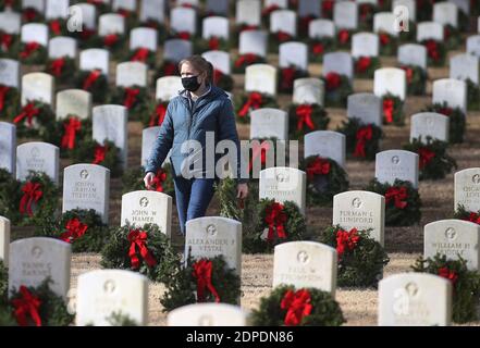 Raleigh, North Carolina, USA. Dezember 2020. JENNIFER HONEYCUTT von Raleigh, NC schloss sich anderen Freiwilligen an, die halfen, über 5000 Kränze während dieses Jahres Kränze in ganz Amerika auf dem Raleigh National Cemetery zu legen. Aufgrund der COVID-19-Einschränkungen war die Kranzniederlegung auf Gruppen von jeweils 50 Personen beschränkt. Der Friedhof, der 1865 gegründet wurde, ist einer von fünf nationalen Friedhöfen, um die Toten der Union zu begraben.Â Er umfasst fast 6,000 Internierungen auf einer Fläche von 7 Hektar. Kränze in ganz Amerika koordiniert wreathÂ--Verlegezeremonien an mehr als 2,100 Standorten in den Vereinigten Staaten, auf See Stockfoto