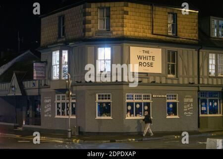 Swansea, Großbritannien. Dezember 2020. Ein Mann mit einer Maske geht an diesem Abend an dem geschlossenen White Rose Pub im kleinen Dorf Mumbles bei Swansea vorbei, bevor es heute Abend um Mitternacht wegen der steigenden Anzahl von Coronavirus-Fällen in Wales und dem Rest des Vereinigten Königreichs zu einer nationalen Sperre von Wales kommt. Quelle: Phil Rees/Alamy Live News Stockfoto