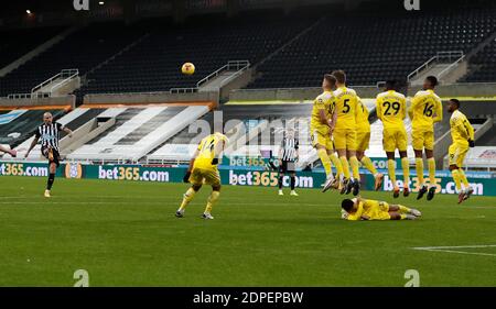 Jonjo Shelvey von Newcastle United nimmt einen Freistoß, als Fulhams Antonee Robinson während des Premier League-Spiels im St. James' Park in Newcastle auf dem Boden der Wand liegt. Stockfoto