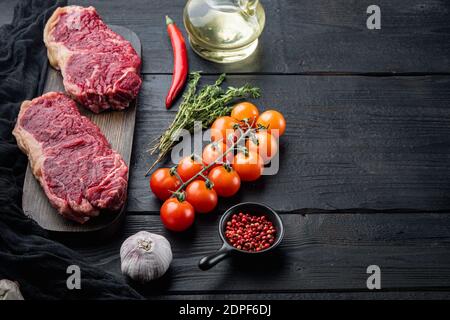 Frisches Rindfleisch ohne Knochen Club rohes Steak, auf schwarzem Holzhintergrund, mit Platz für Text Stockfoto