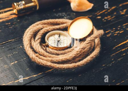 Rollseil und Vintage Kompass auf dunklem Holzhintergrund Stockfoto