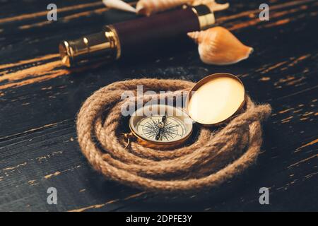 Rollseil und Vintage Kompass auf dunklem Holzhintergrund Stockfoto