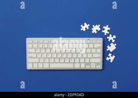 Computertastatur und Puzzles auf farbigem Hintergrund Stockfoto