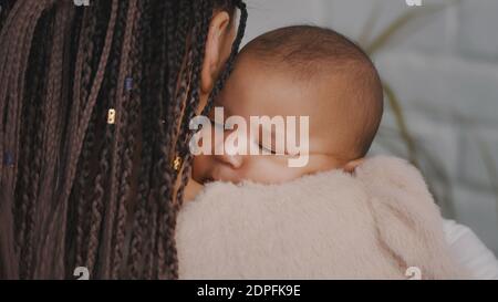 Nahaufnahme des schönen Mulatto Baby schlafen in den Händen der Mutter. Hochwertige Fotos Stockfoto