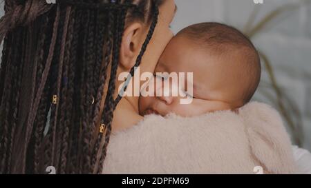 Nahaufnahme des schönen Mulatto Baby schlafen in den Händen der Mutter. Hochwertige Fotos Stockfoto