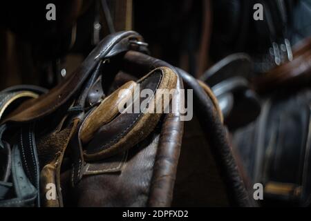 Pferdehaltsattel aus Leder, der an einer Holzwand hängt Stockfoto