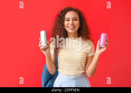 Schöne afroamerikanische Frau mit Soda auf farbigem Hintergrund Stockfoto