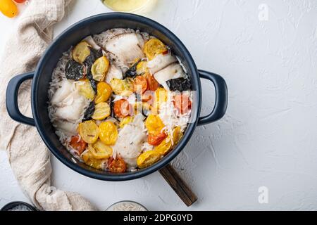 Eine Pfanne fabelhafter Fisch, mit Basmati-Reis und Kirschtomaten, auf weißem Hintergrund, Draufsicht Stockfoto