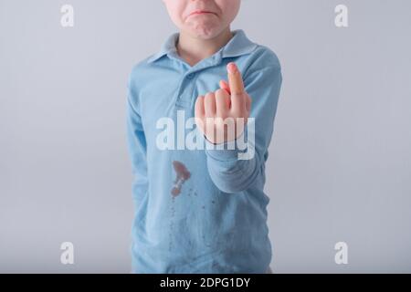 Nahaufnahme von Kind Finger mit Kleben-Gips. Schmutzige Blutfleck auf T-Shirt auf dem Hintergrund. Platz für Text Stockfoto