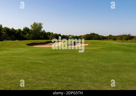 Ein Paar Sandfalle Gefahren in einem ordentlich gepflegten Golf Fairway auf einem sonnigen mit Bäumen säumen die weiten Grenzen des Kurses. Stockfoto