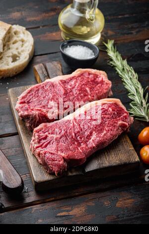 Steak Burger Zutaten mit Rindfleisch, marmoriertem Fleisch, auf dunklem Holzhintergrund Stockfoto