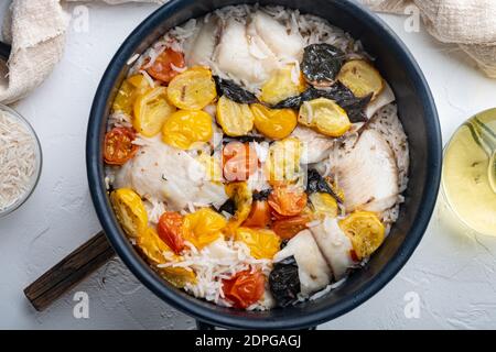 Eine Pfanne fabelhafter Fisch, mit Basmati-Reis und Kirschtomaten, auf weißem Hintergrund, Draufsicht Stockfoto