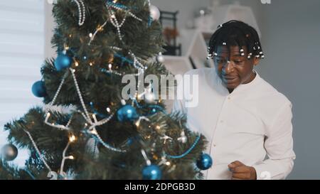 Weihnachtsstimmung. Happy african american schwarzen Mann Dekoration Weihnachtsbaum. Hochwertige Fotos Stockfoto