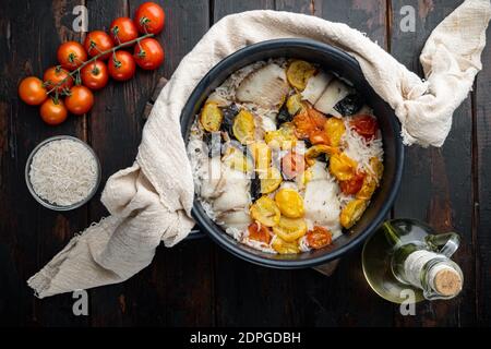 Eine Pfanne fabelhaften Fisch, mit Basmati-Reis und Kirschtomaten, auf alten Holztisch, Blick von oben Stockfoto