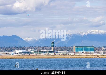 RICHMOND, KANADA - 05. APRIL 2020: Vancouver International Airport YVR mit den Coast Mountains im Hintergrund und dem Fraser River im Vordergrund Stockfoto