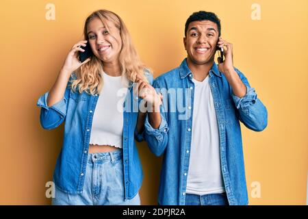 Junge interracial Paar mit Gespräch auf dem Smartphone schreien stolz, feiert Sieg und Erfolg sehr aufgeregt mit erhobenem Arm Stockfoto