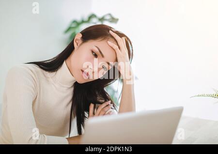 Gestresste Frau Gefühl müde und Sorgen über die Arbeit Problem suchen Bei einem Laptop Stockfoto