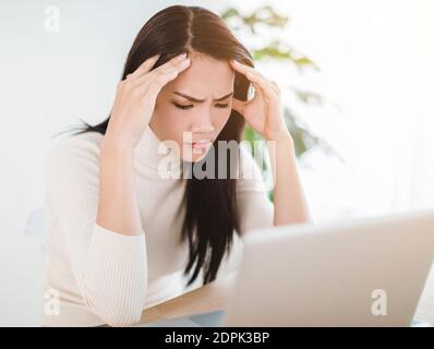 Gestresste Frau Gefühl müde und Sorgen über die Arbeit Problem suchen Bei einem Laptop Stockfoto