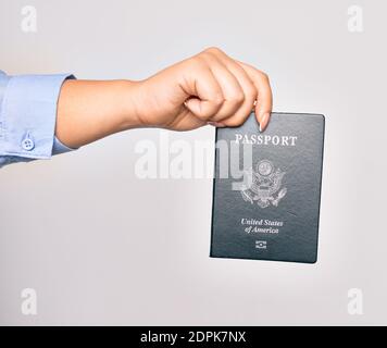 Hand der kaukasischen jungen Frau, die ein passdokument der vereinigten Staaten auf isoliertem weißem Hintergrund hält Stockfoto