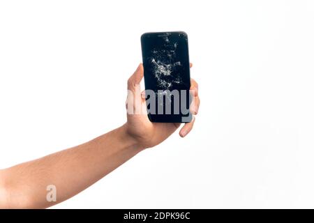 Hand von kaukasischen jungen Mann hält gebrochene Smartphone zeigt geknackt Bildschirm über isolierten weißen Hintergrund Stockfoto