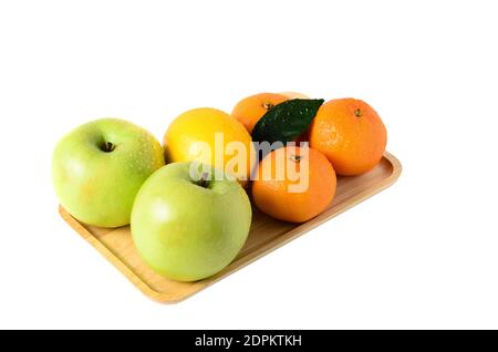Obst auf einem Holztablett. Äpfel, Mandarinen und Zitrone isoliert auf weißem Hintergrund. Selektiver Fokus. Stockfoto