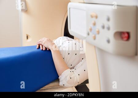 Frau beim Durchlaufen eines computergesteuerten CAT-Scanners für axiale Tomographie. Medizinische Untersuchung, Untersuchung in einem modernen Krankenhaus Stockfoto