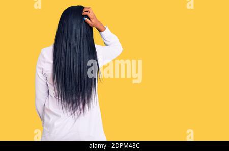 Junge afroamerikanische Frau trägt Arzt Stethoskop rückwärts denken Zweifel mit Hand auf Kopf Stockfoto