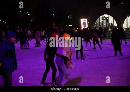 Besucher des öffentlichen Raums der Schokoladenfabrik Roshen Schlittschuh auf einer Eisbahn. Weihnachtsunterhaltung in Kiew. Stockfoto