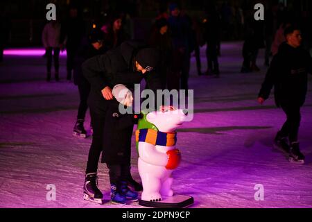 Besucher des öffentlichen Raums der Schokoladenfabrik Roshen Schlittschuh auf einer Eisbahn. Weihnachtsunterhaltung in Kiew. Stockfoto