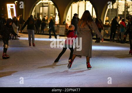 Besucher des öffentlichen Raums der Schokoladenfabrik Roshen Schlittschuh auf einer Eisbahn. Weihnachtsunterhaltung in Kiew. Stockfoto