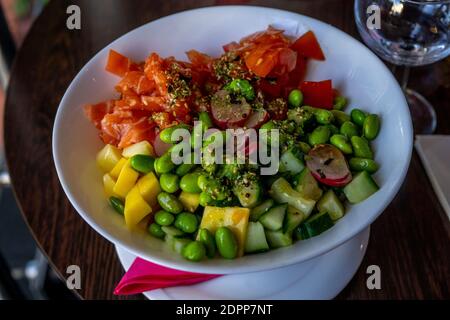 Lachs mit Avocado und Mango, Algen, eingelegten Karotten, Gurke. Nahaufnahme Stockfoto