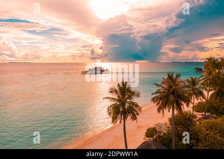 Luftaufnahme Sonnenaufgang Sonnenuntergang Strand Bucht Blick, bunten Himmel und Wolken, hölzerne Anlegestelle über Wasser Bungalow. Meditation Entspannung tropische Drohne Blick, Meer Ozean Stockfoto