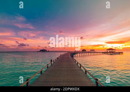 Sonnenuntergang auf den Malediven Insel, Luxus Water Villas Resort und hölzernen Pier. Schönen Himmel und Wolken und Strand Hintergrund für Sommer Urlaub Stockfoto