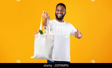 African Man Holding Eco Bag Gestikulieren Wie, Gelber Hintergrund Stockfoto