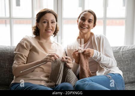 Kopf erschossen Porträt lächelnd reife Mutter und Erwachsene Tochter Stricken Stockfoto